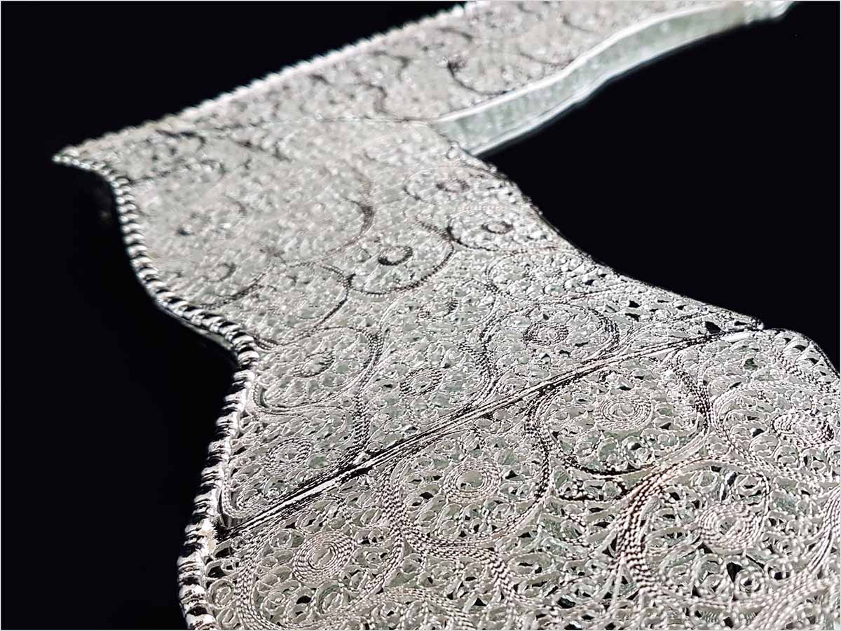 Handmade Persian mirror with intricate silver-coated copper filigree patterns.