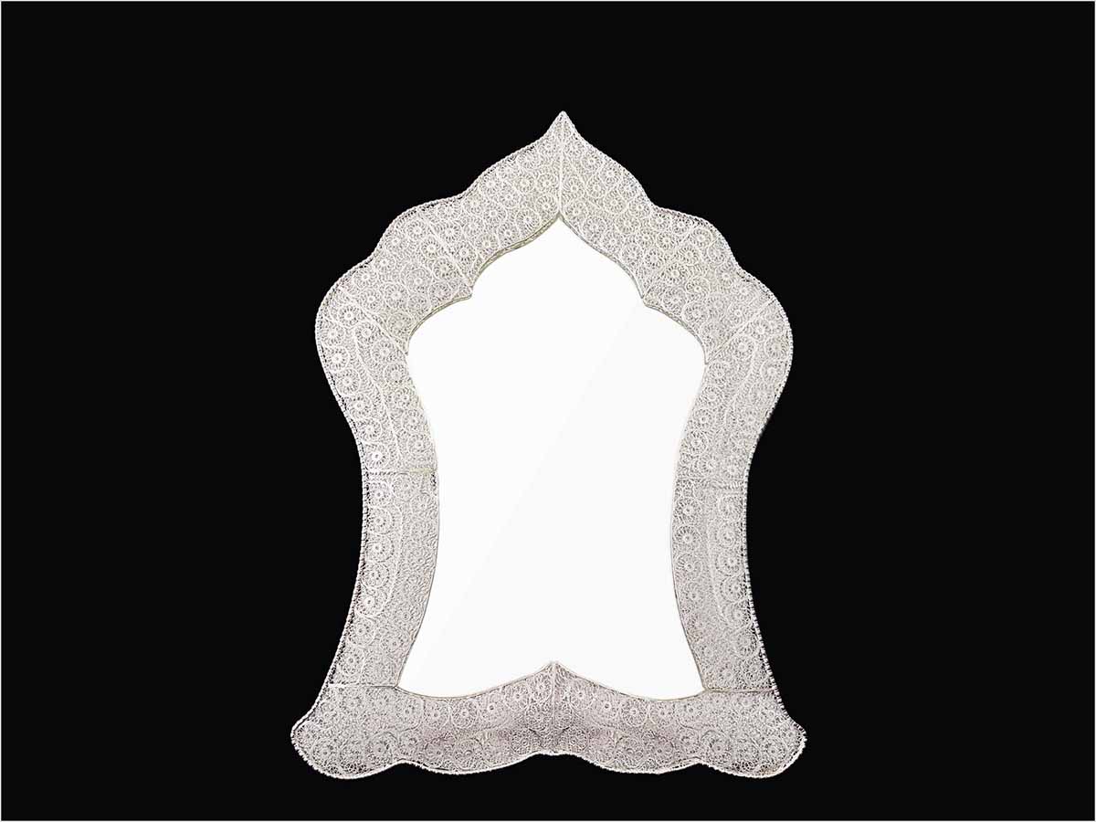Handmade Persian mirror with intricate silver-coated copper filigree patterns.
