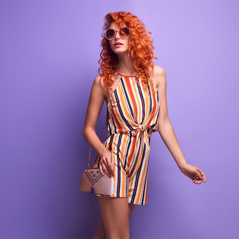 A pink Baluchi mirror-work embroidery crossbody bag with a chain accent.