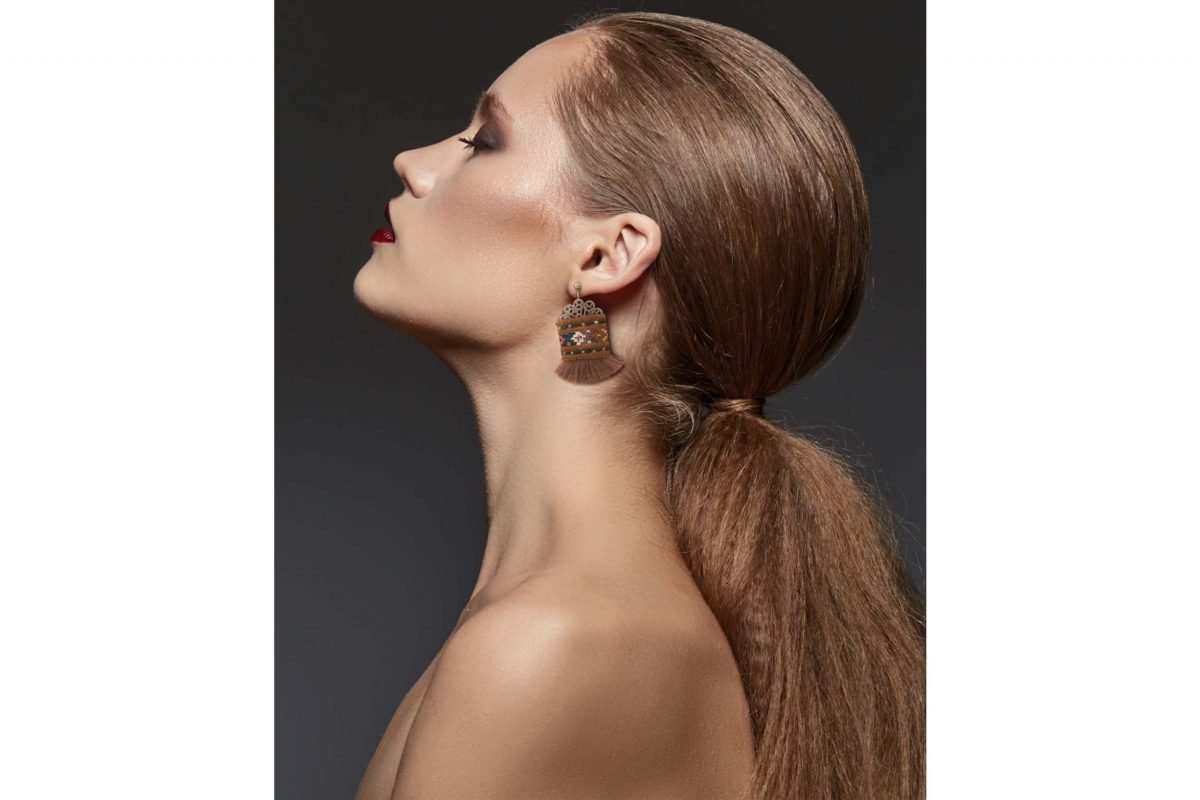 A close-up image of Craftestan's handcrafted Baluchi earrings, featuring intricate embroidery and charming tassels.