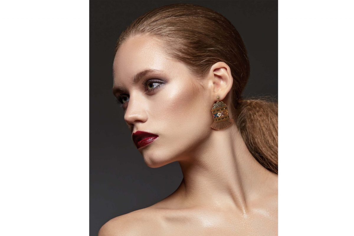 A close-up image of Craftestan's handcrafted Baluchi earrings, featuring intricate embroidery and charming tassels.