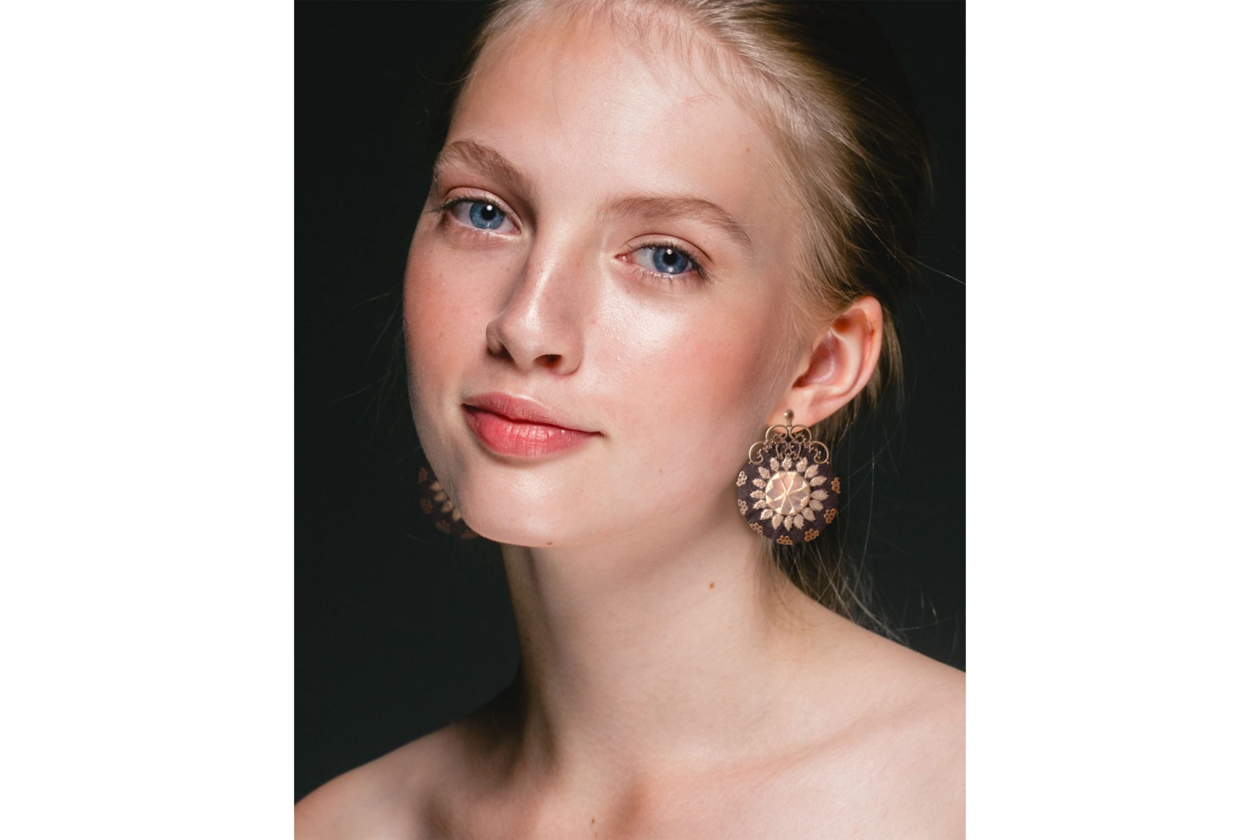 Image of Baluchi embroidered circular earrings with a traditional design in black and yellow colours.