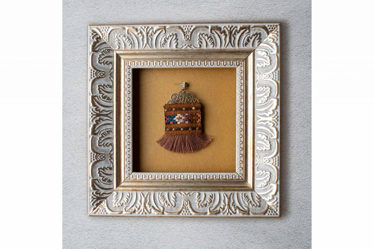 A close-up image of Craftestan's handcrafted Baluchi earrings, featuring intricate embroidery and charming tassels.