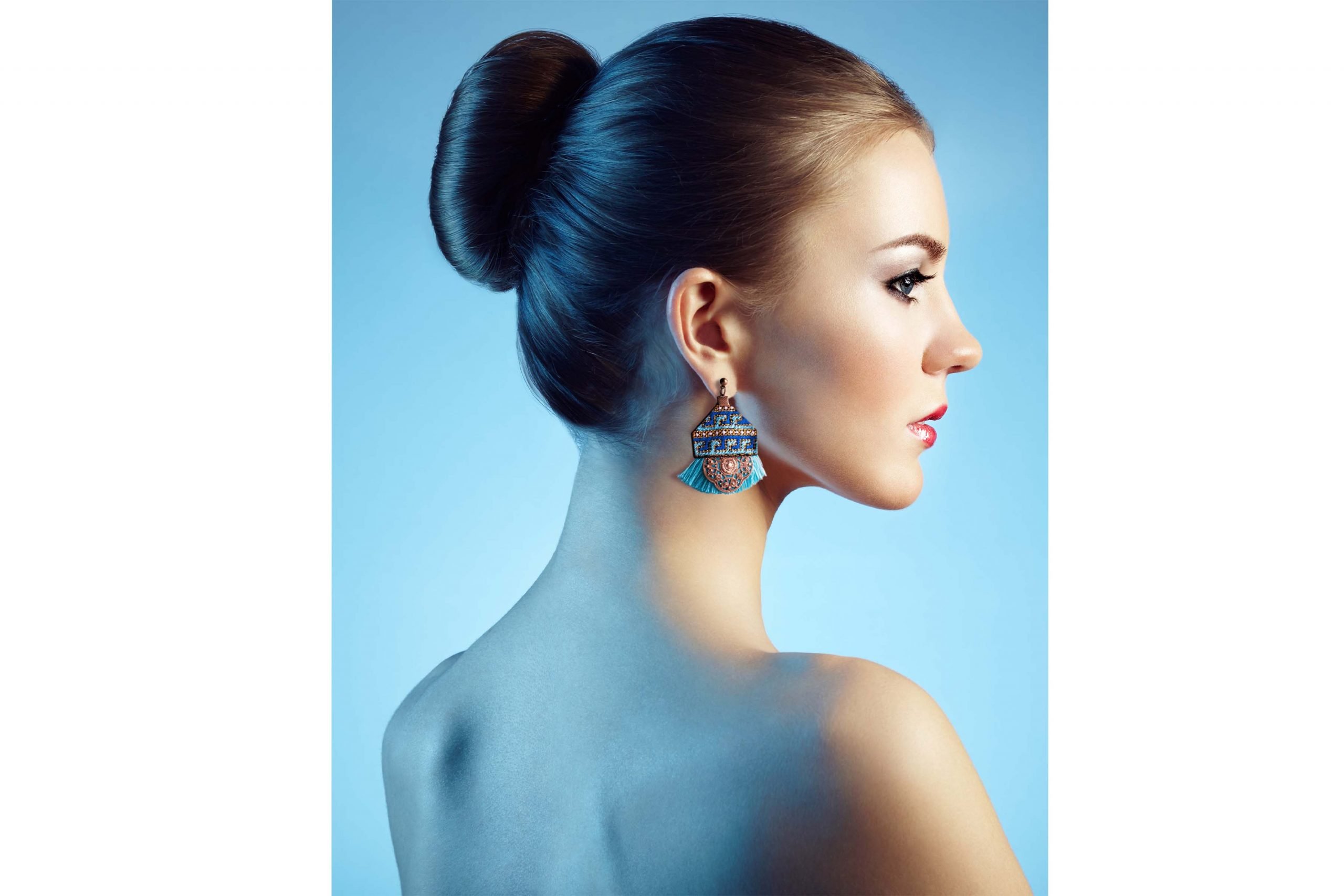 A pair of Bohemian Geometric Baluchi Embroidered Earrings, featuring a blue, yellow, and orange geometric pattern and blue tassels at the bottom.