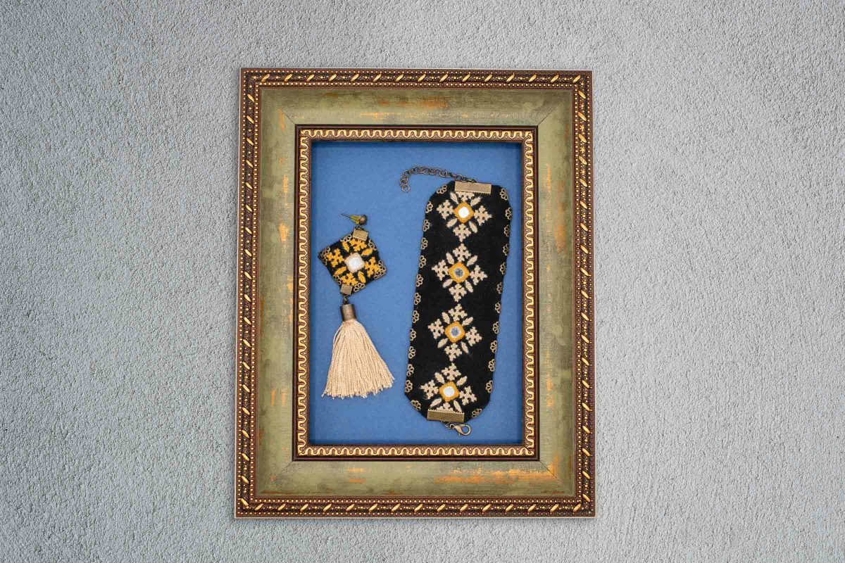 Elegant hand-embroidered Baluchi accessory set featuring a pair of earrings and a matching bracelet with intricate designs.