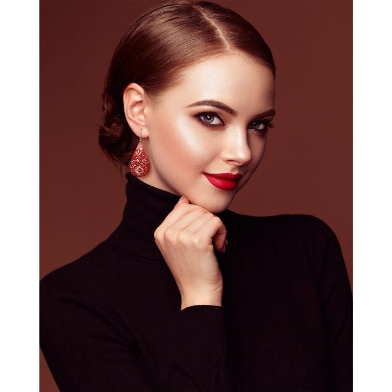 Beautiful model wearing Biomorphic Teardrop Earrings, expertly hand-painted with Islimi and biomorphic patterns. The Crimson colour complements her skin tone.