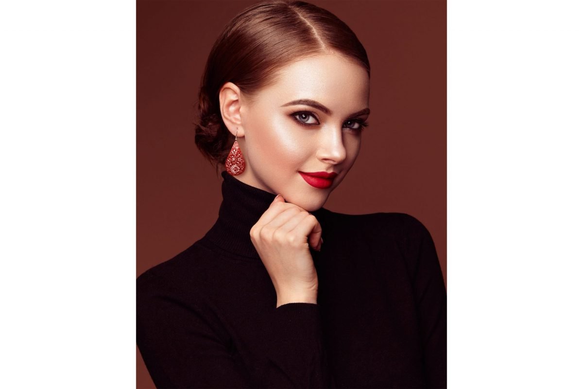 Beautiful model wearing Biomorphic Teardrop Earrings, expertly hand-painted with Islimi and biomorphic patterns. The Crimson colour complements her skin tone.