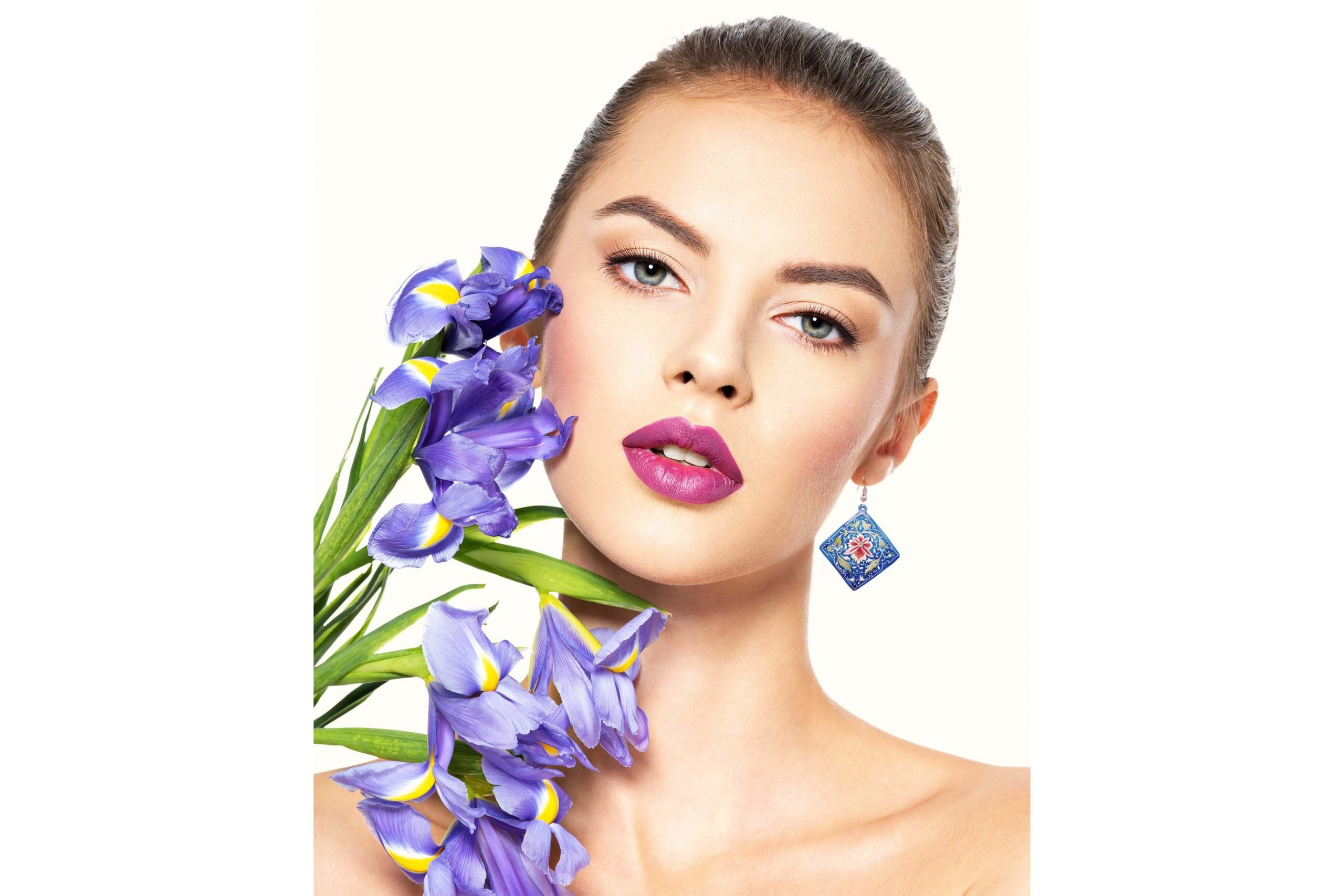 Model wearing Hand-Painted Persian Earrings with a floral design made of enamelled copper and silver hook.
