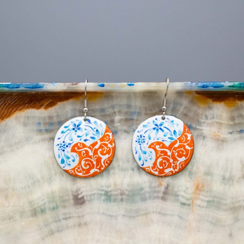 Front view of circular Persian-inspired enamelled earrings with watercolour painting and silver hook.