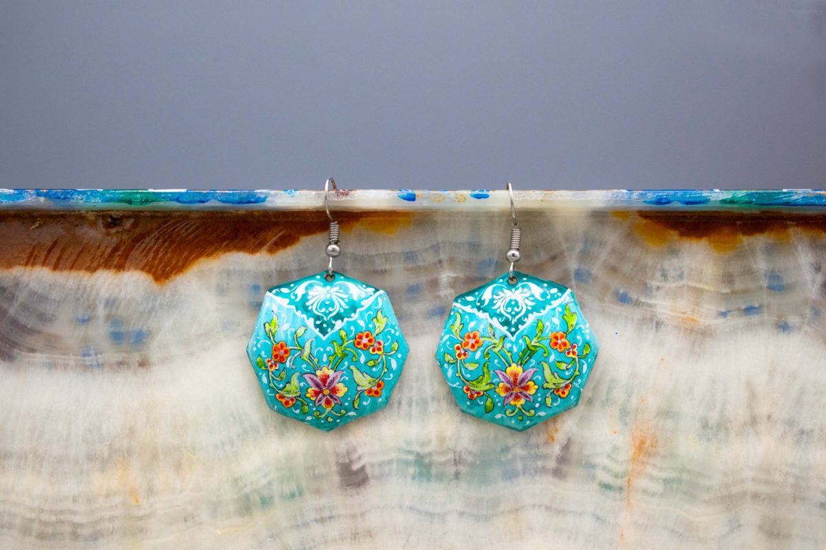 A pair of viridescent enamel earrings with a delicate foliage design, made of enamelled copper and silver hooks.
