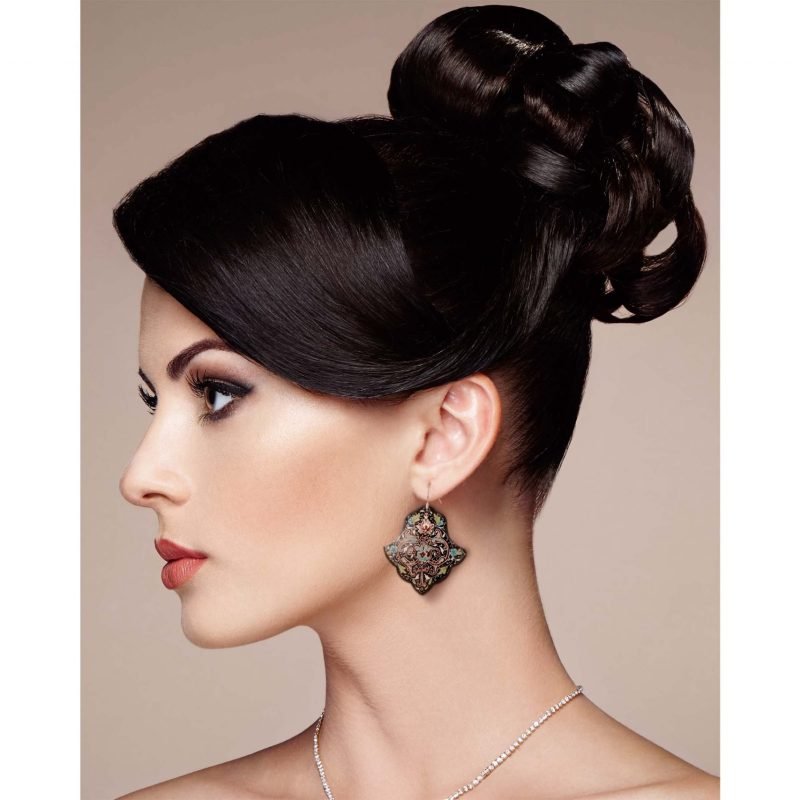 Front view of a beautiful female model wearing Hand-Painted Persian Enamel Watercolour Painting Earrings, featuring a unique Persian garden design in blue, red, and black hues. The earrings are made of enamelled copper with titanium hooks, and each measures 5cm in height and 2.5cm in width.