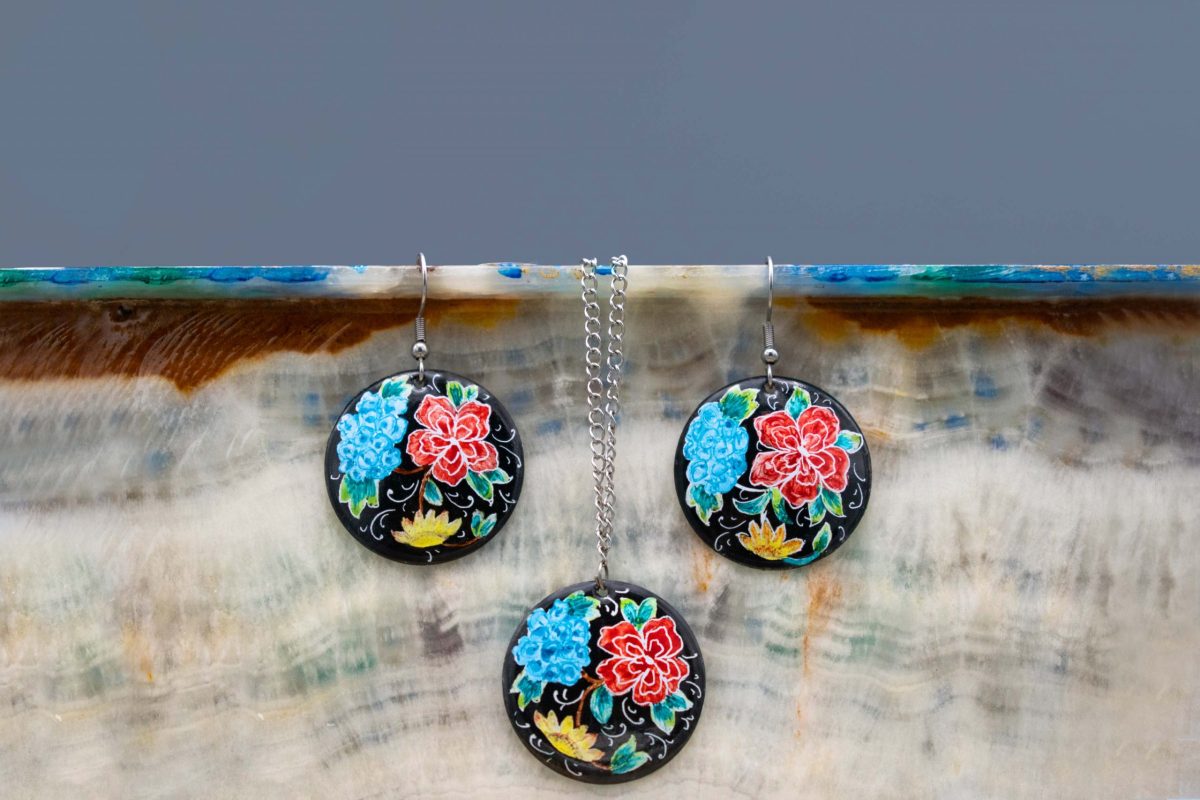 Front view of Persian enamel watercolour painting earrings and a pendant set, made of enamelled copper with titanium hook and chain. Features a hand-painted Persian garden pattern in blue, red and black. The earrings measure 5cm in height and 2.5cm in width, while the pendant measures 7cm in height and 5cm in width.