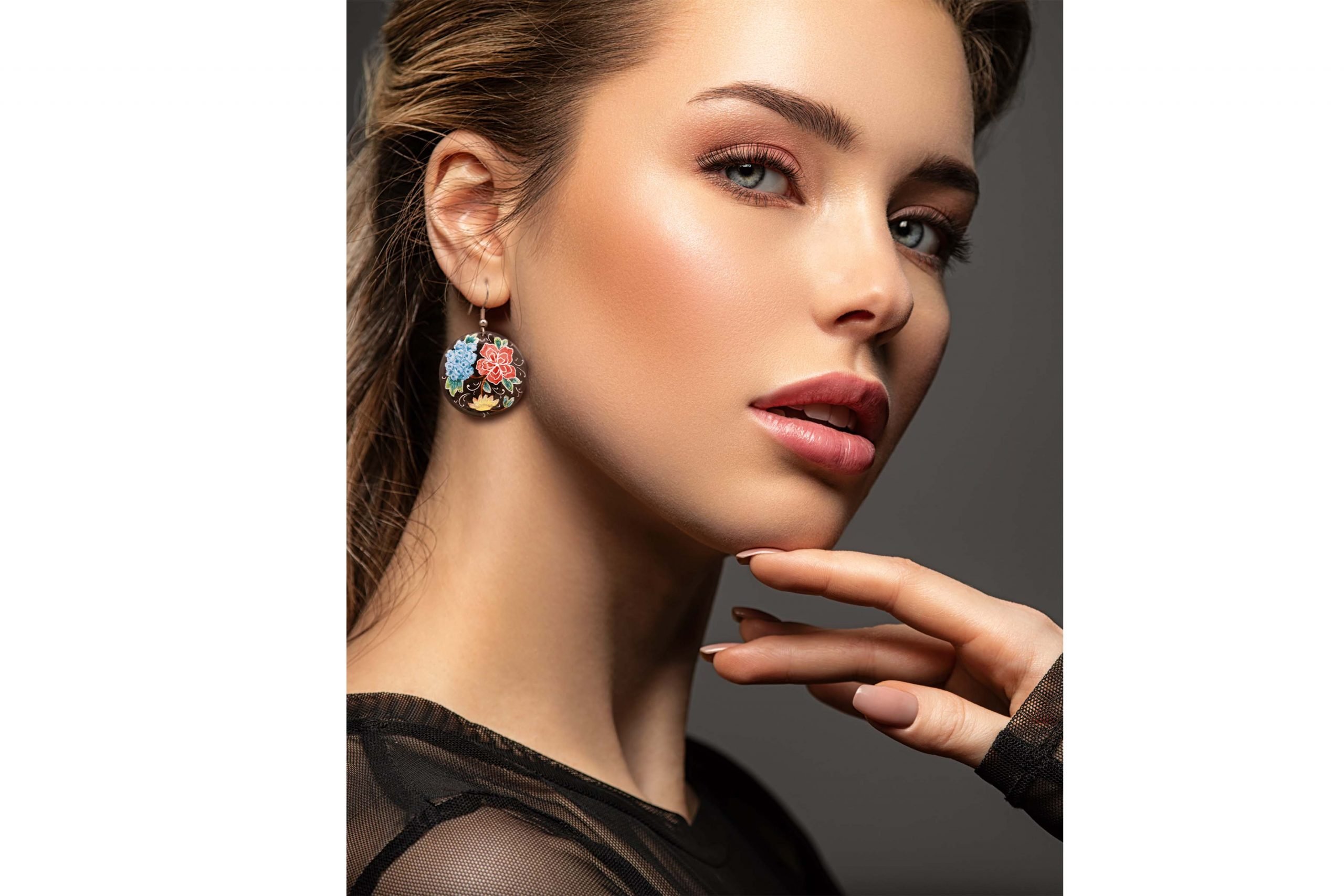 Front view of a beautiful female model wearing Hand-Painted Persian Enamel Watercolour Painting Earrings, featuring a unique Persian garden design in blue, red, and black hues. The earrings are made of enamelled copper with titanium hooks, and each measures 5cm in height and 2.5cm in width.