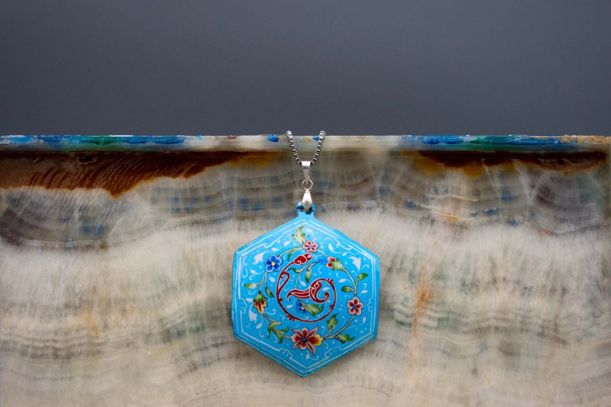 Enamel watercolour painting pendant with Persian garden design, skillfully hand-painted by a master artisan. Made of enamelled copper with titanium chain. The pendant measures 7cm in height and 5cm in width. Sky blue colour.