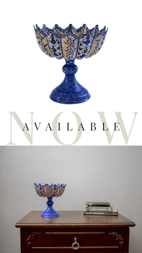 A close-up view of a Persian enamel stem bowl, with a stunning hand-painted floral and foliate pattern in shades of blue, green, and gold.