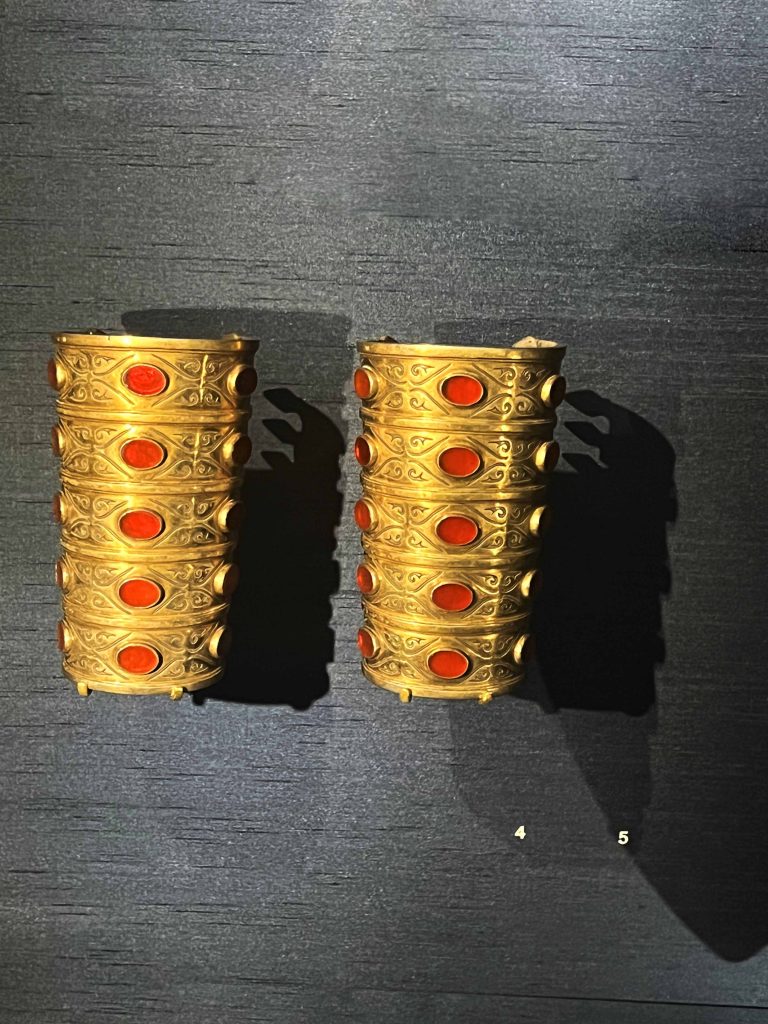 A pair of intricately designed Turkmen bracelet on display in the British Museum. Keywords: Turkmen, earrings, cultural heritage, wealth, status, natural world, Silk Road, traditional design, contemporary design, craftsmanship.