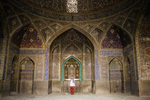 A photo of Jameh Mosque in Esfahan, Iran. The mosque features a beautiful blue mosaic decor and an impressive dome. It is surrounded by lush greenery and is a popular tourist destination in Iran.