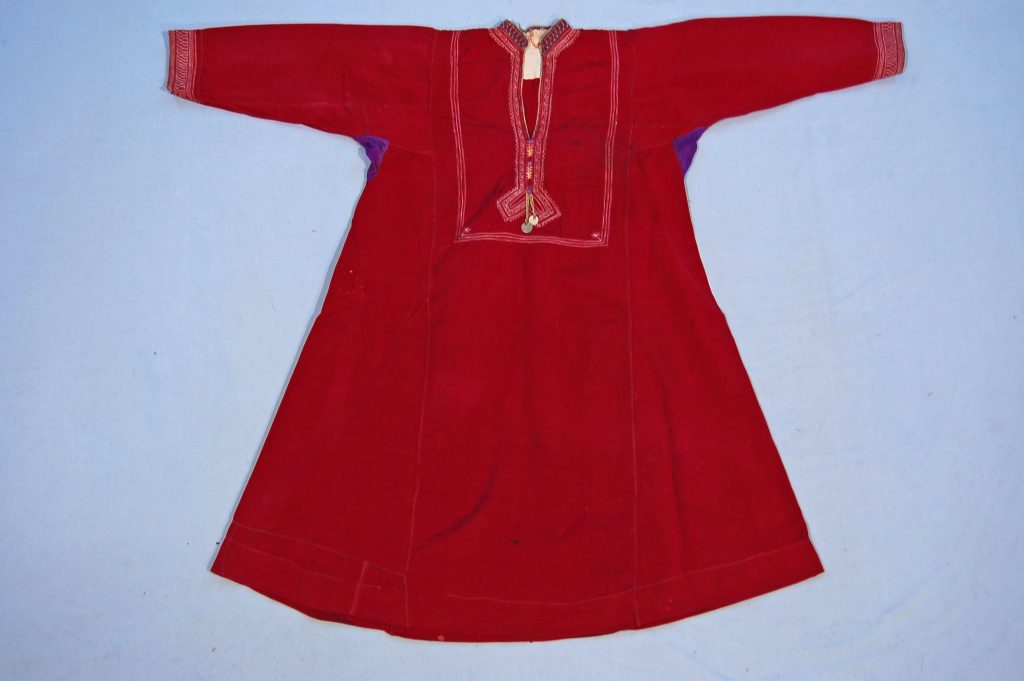 This beautifully crafted woman’s shift is made from cloth and adorned with coins, showcasing the intricate embroidery typical of Turkmen craftsmanship. The shift features detailed stitching that reflects the cultural heritage of the Turkmen ethnic group, blending functionality with artistry. Acquired in Iran, this garment exemplifies the rich textile traditions and decorative techniques prevalent in the region.