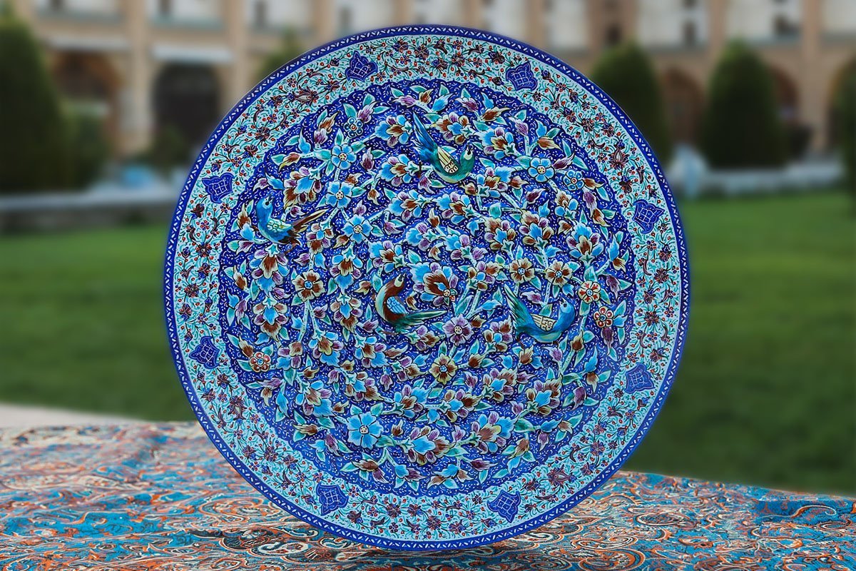 A Hand-crafted Persian Enamelled Plate by Craftestan, with a vibrant design of nightingales and flowers, reflective of Persian culture.