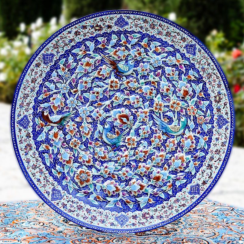 A Hand-crafted Persian Enamelled Plate by Craftestan, with a vibrant design of nightingales and flowers, reflective of Persian culture.