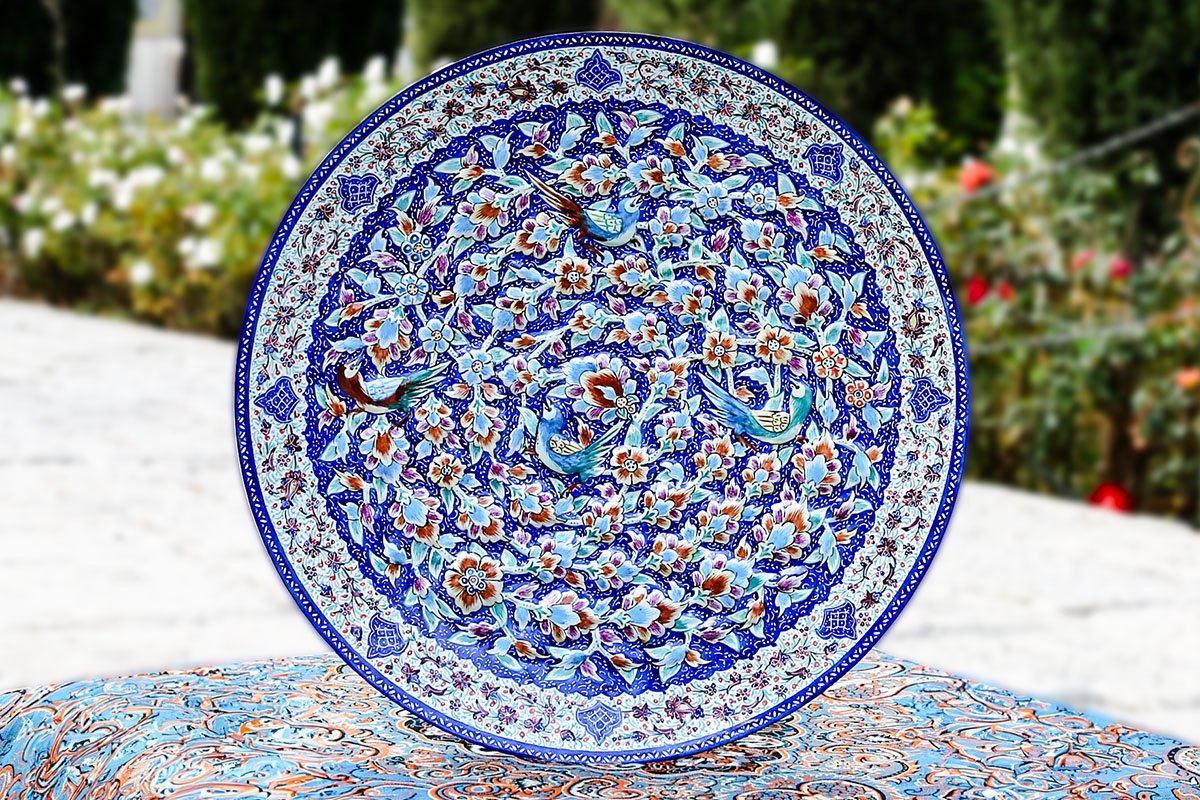 A Hand-crafted Persian Enamelled Plate by Craftestan, with a vibrant design of nightingales and flowers, reflective of Persian culture.