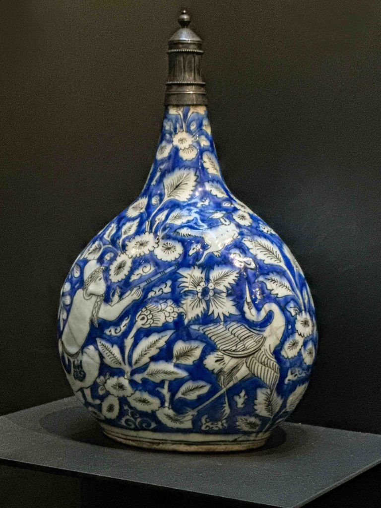 A Safavid Khata'i Persian Art bottle crafted from stonepaste, featuring cobalt blue and chromium black paintings, showcasing scenes of European-inspired figures and hunting motifs. Khata'i Persian Art