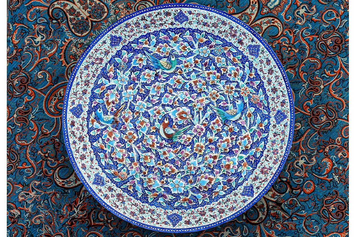 A Hand-crafted Persian Enamelled Plate by Craftestan, with a vibrant design of nightingales and flowers, reflective of Persian culture.