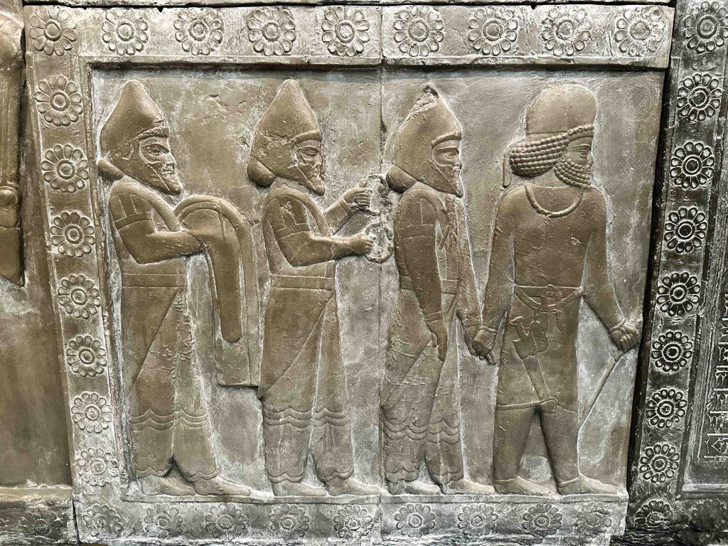 An intricate 19th-century plaster cast depicting a procession of figures from the Palace of Darius at Persepolis, Iran, carrying gifts and led by a robed man, showcases the workmanship of ancient times with some parts left unfinished. Ancient Persian Clothing