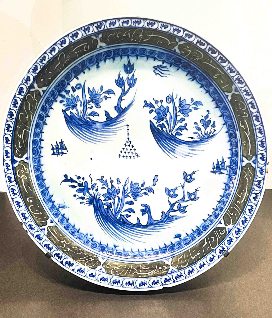 A remarkable Khata'i Persian Art dish from the Ilkhanid dynasty, featuring underglaze black, blue, and turquoise paintings, including a chinoiserie bird within a panelled border. Khata'i Persian Art