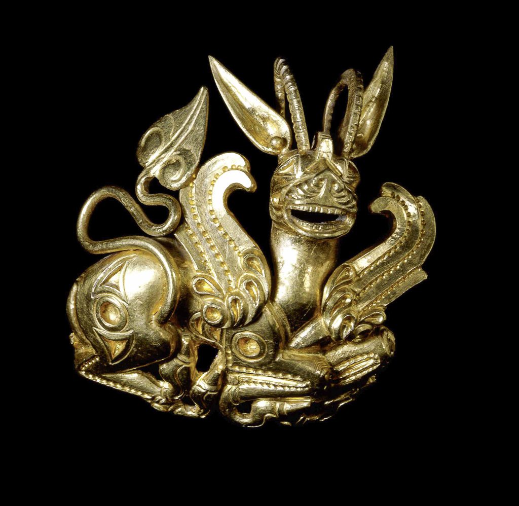 Gold plaque ornament depicting a recumbent lion-griffin, likely used as a hair or cap ornament from the Achaemenid period. ancient Persian jewellery