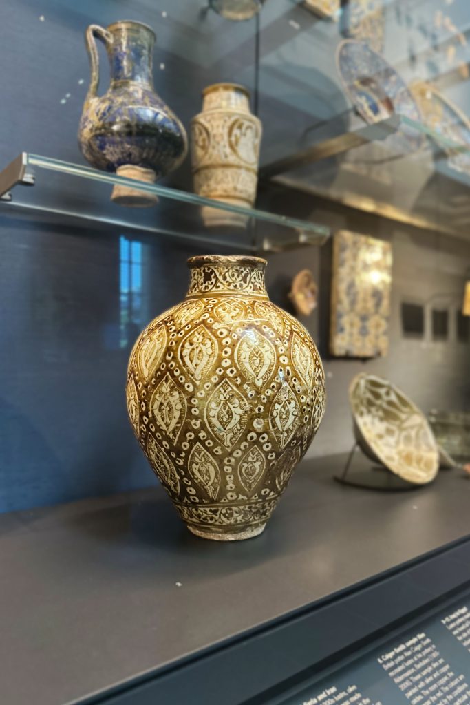 This yellow-brown painted ceramic jar from the late 13th century, adorned with intricate medallions and prunus blossoms, showcases Islamic artistry and marks an important moment in the history of enamelling.