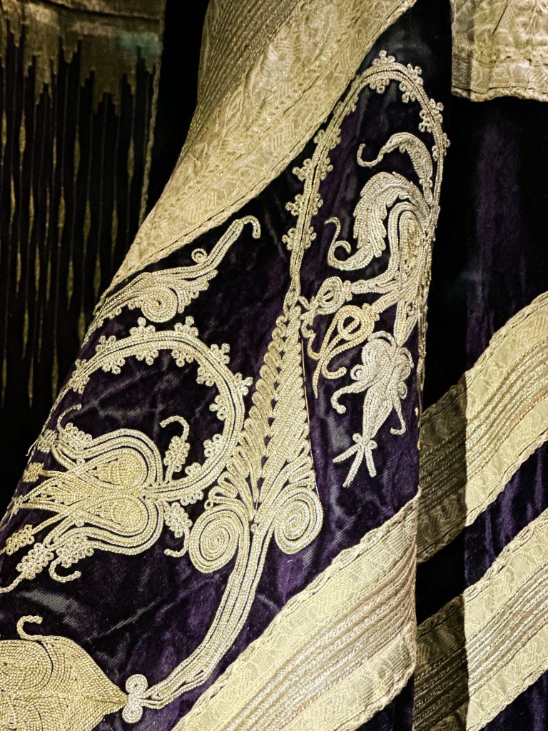 Deep purple silk velvet džube coat from Prizren, adorned with gold and silver Ottoman-style floral patterns and lined with red and yellow stripes. Ottoman Empire Attire.