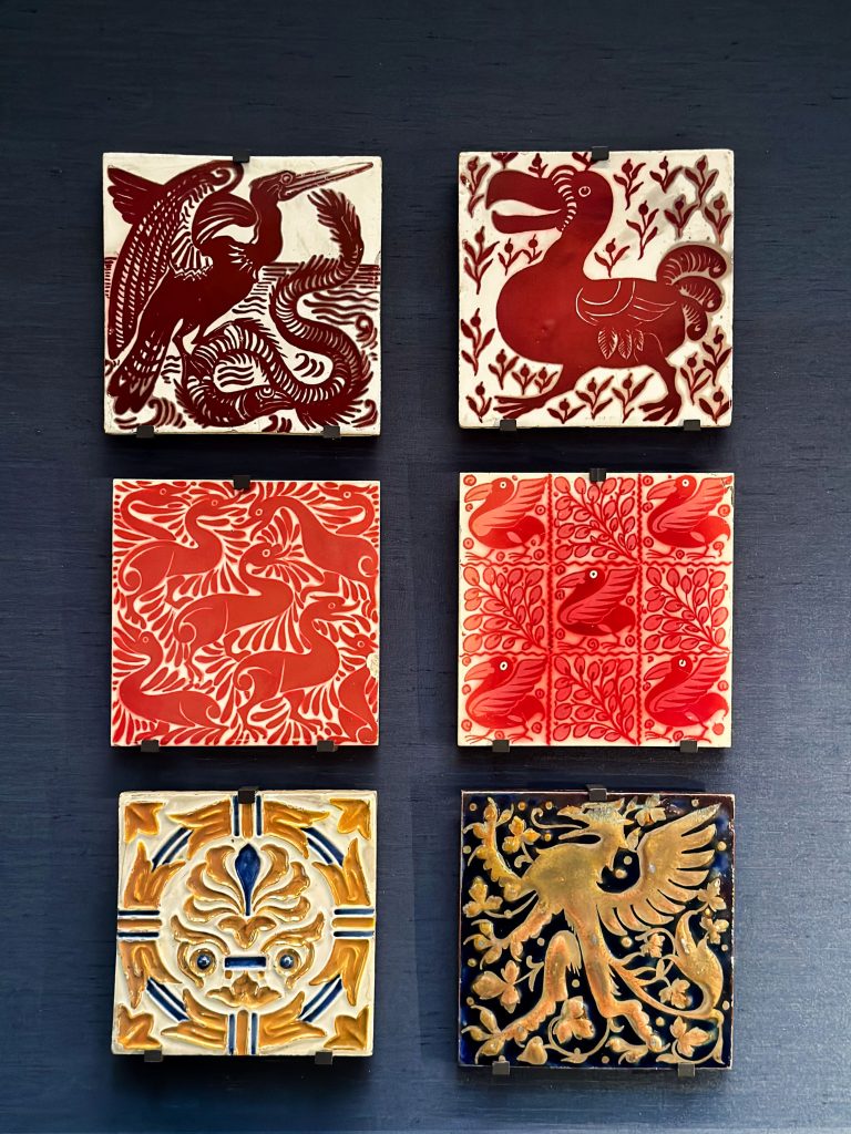 A collection of European tiles featuring designs such as anthemions, griffins, cranes, and duck-like creatures, created using Islamic-influenced lustre techniques, highlights the cross-cultural exchanges in the history of enamelling.