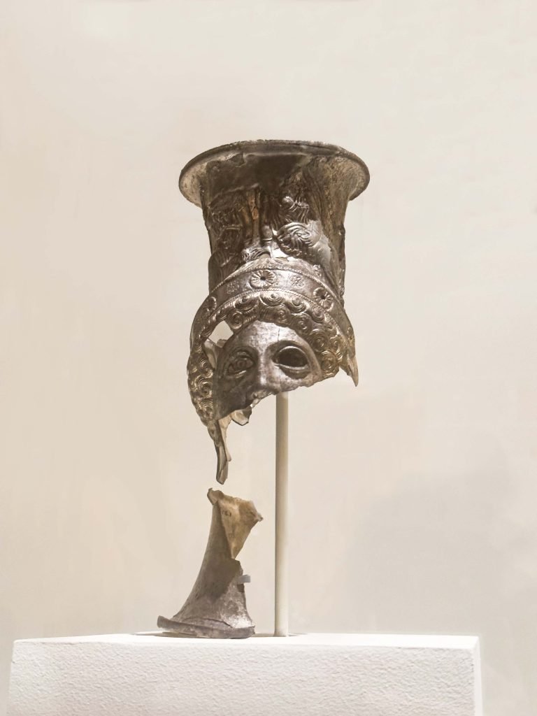 A meticulously crafted Lycian Drinking Cup showcasing the fusion of Persian elegance and Greek artistry, rich with multicultural narratives, detailed repousse decoration, and gilded panels, symbolizing the convergence of diverse cultures in the realm of luxury