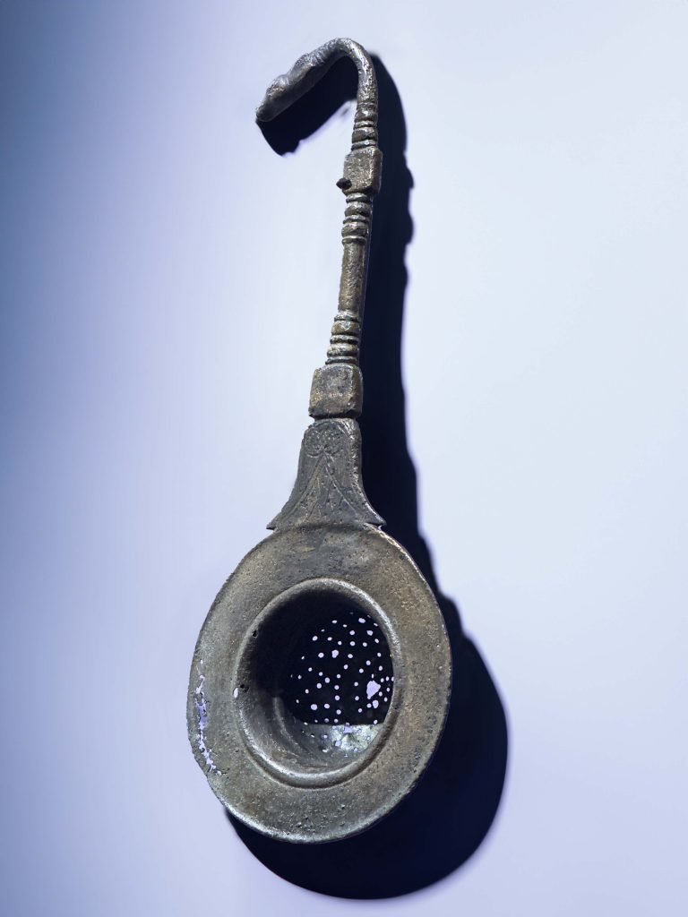 Achaemenid silver wine-strainer with calf-head terminal and engraved inscriptions, symbolizing ancient Persian refinement in wine consumption and Persian drinks.