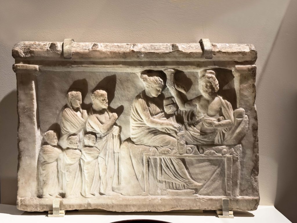 A detailed Greek relief from the 4th - 3rd century BC depicting the divine symbolism of Persian drinking vessels, illustrating the merging realms of mortals and gods, and the intertwined destinies of Greek and Persian cultures.