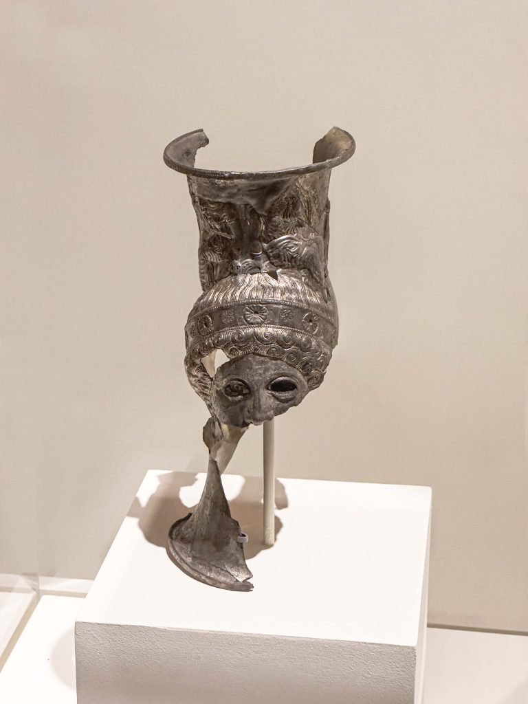 A meticulously crafted Lycian Drinking Cup showcasing the fusion of Persian elegance and Greek artistry, rich with multicultural narratives, detailed repousse decoration, and gilded panels, symbolizing the convergence of diverse cultures in the realm of luxury