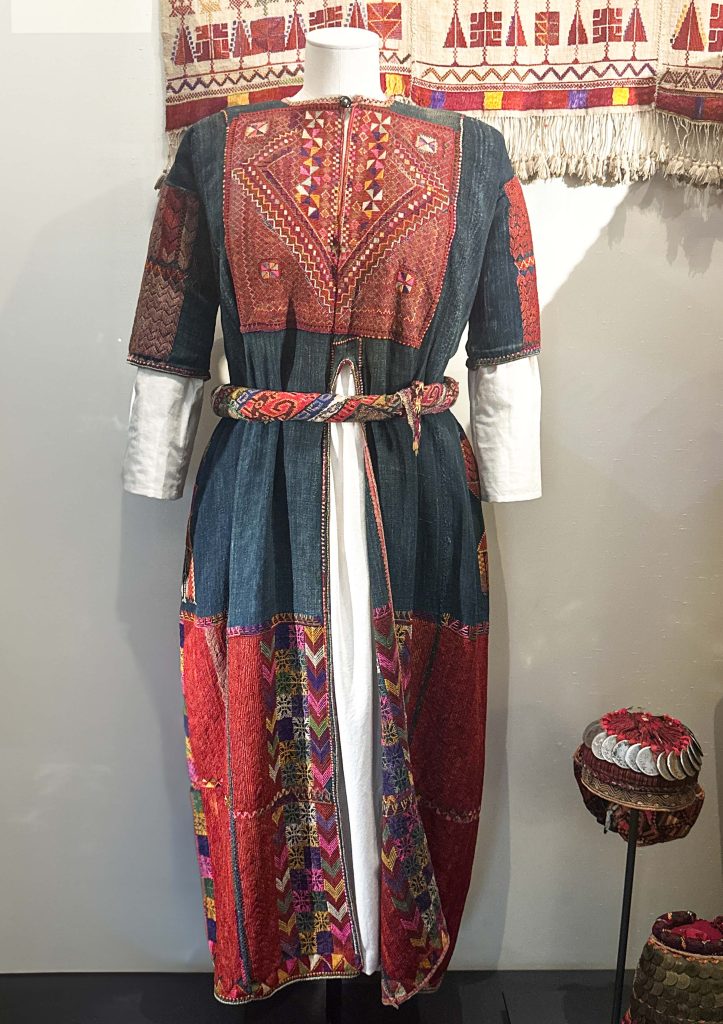 Detailed embroidery on the indigo-dyed linen of the Ramallah jillayeh, a testament to traditional Arabian clothing and Palestinian artistry.