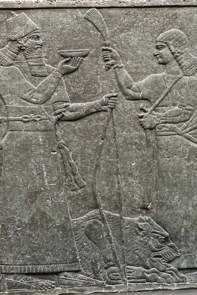 Gypsum wall panel relief from the Neo-Assyrian era, depicting Ashurnasirpal II pouring libation over a deceased lion, accompanied by musicians playing harps and a cuneiform inscription.