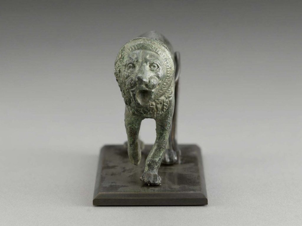 Bronze figurine of a passant lion from the Achaemenid period, showcasing intricate craftsmanship.