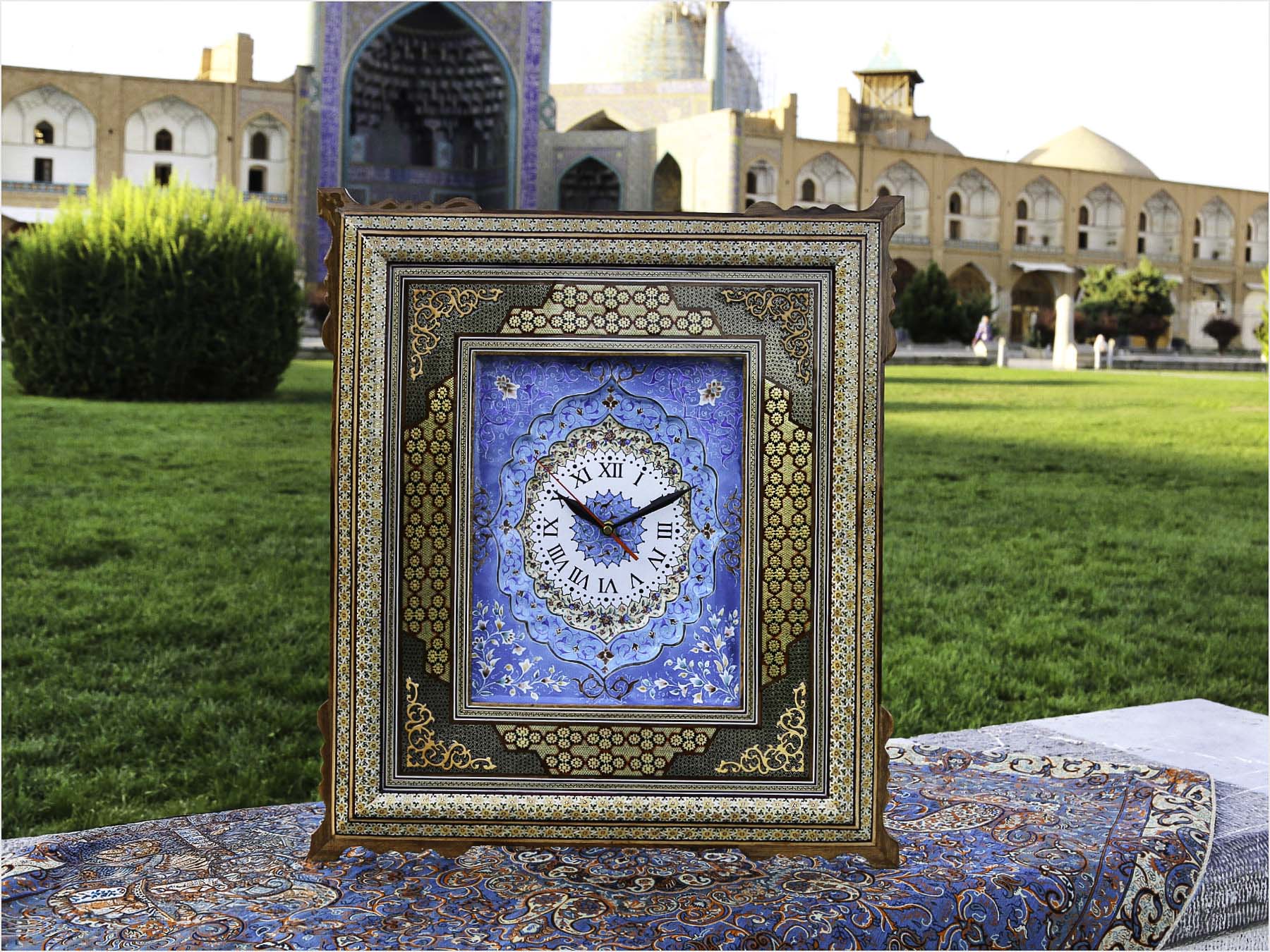Handcrafted Persian wall clock with Mina-Kari enamel dial and Khatam-Kari inlay, made in Isfahan from wood, brass, and camel bone, measuring 55 cm x 50 cm.